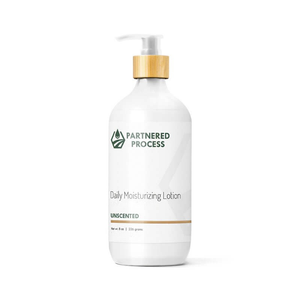 White pump bottle of unscented lotion with bamboo-topped dispenser and Partnered Process label.