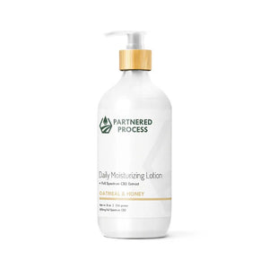 White pump bottle of Partnered Process oatmeal and honey CBD lotion with bamboo cap.
