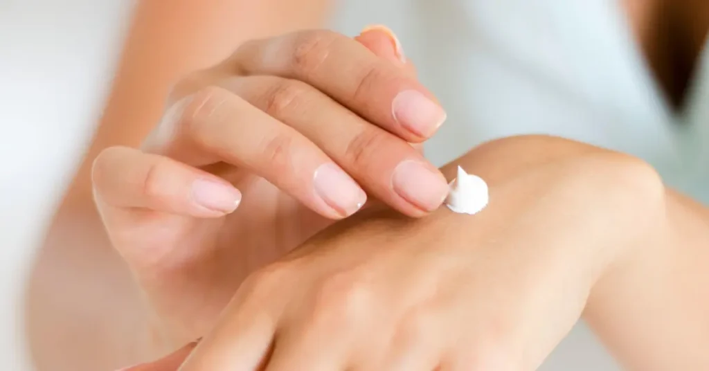 CBD body cream being gently applied to the back of a hand, showing skin hydration and care.