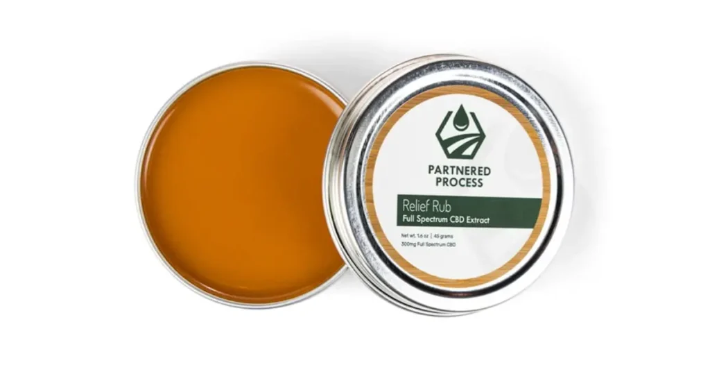 CBD balm tin of relief rub showing smooth amber salve in metal container