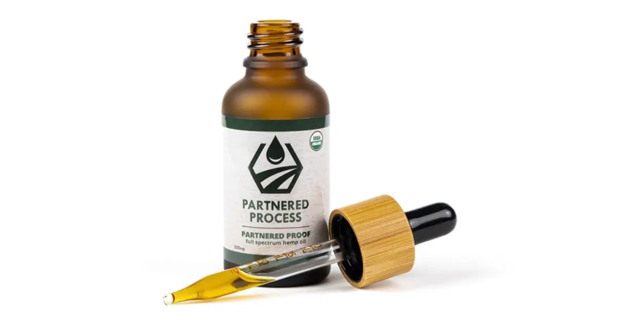CBD for joint pain tincture with bamboo dropper shown beside an open bottle.